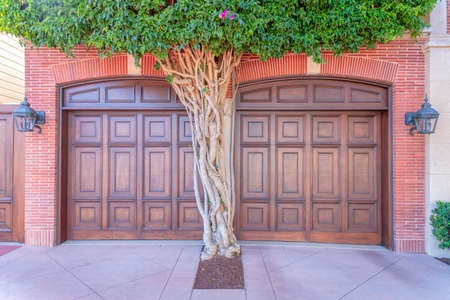 Garage exterior with two wooden garage doors and red bricks wallの写真素材