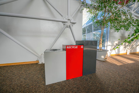 Three trash bins on a brown granite flooring inside a building in Tucson, Arizonaの写真素材