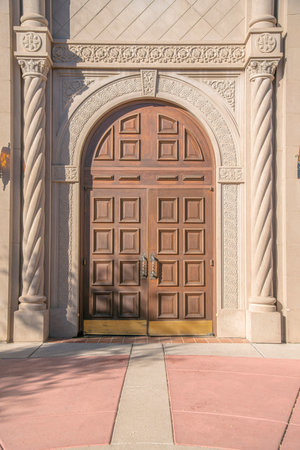 Arched wooden double door with decorative stone doorframe at downtown Tucson, Arizonaの写真素材