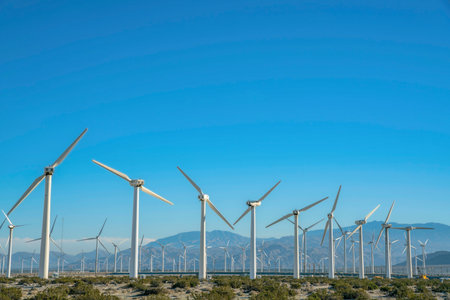 Windmills or high wind turbines that generates renewable electricity. Green energy concept with...