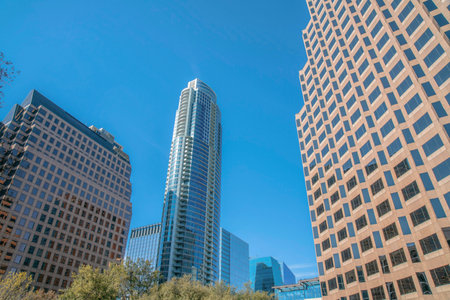 Austin, Texas- Views of modern high rise corporate and residential buildings. There are two buildings at the front with tile wall claddings and glass buildings at the back against the sky background.の写真素材