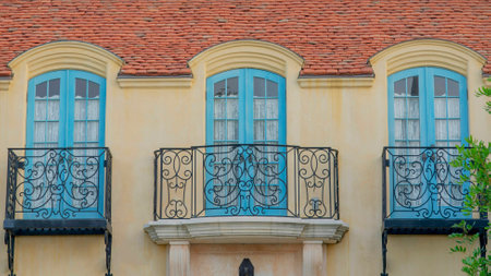 Panorama White puffy clouds Balconies with wrought iron railings and light blue side-hinged doors at...