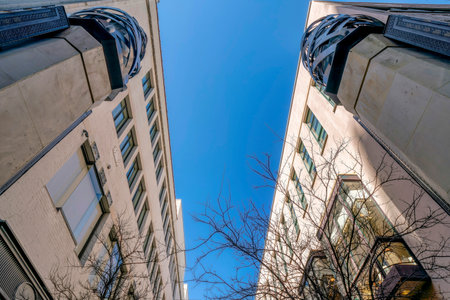Looking up at buildings exterior with modern architecture against blue sky. Facade of apartments or offices in downtown San Antonio Texas viewed on a sunny day.の写真素材