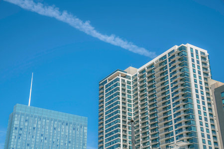 View of two glass residential buildings at Austin, Texas. There is a building on the left with glass...