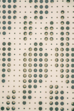 San Antonio, Texas- Beige perforated metal sheet wall. Close-up of a metal wall with decorative...