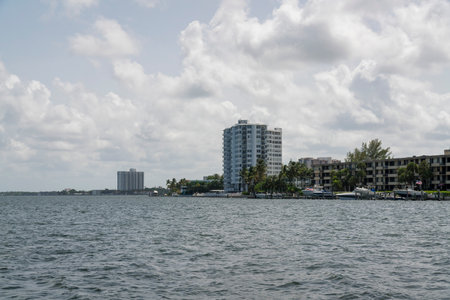 Miami bay at Florida cloudy skyline above the apartments and condominiums. There is a view of the water at the front and yachts at the front of the building on the right.の写真素材
