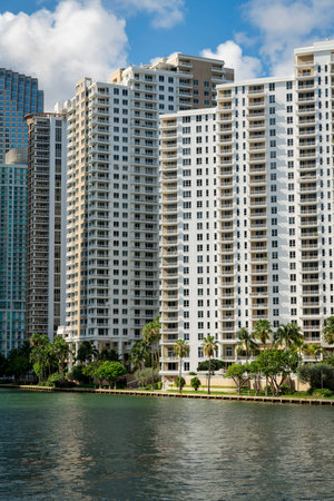 Oceanfront luxury condominiums at the bay in Miami, Florida. There are trees near the shore at the front of the multi-storey residential buildings with balconies.の写真素材