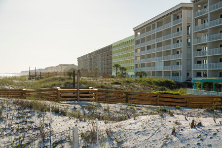 Hotel buildings with wood pathways on a white sand dunes outdoors in Destin, Florida. Beachfront hotel buildings against the white sky background.の写真素材