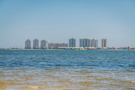 Modern high-rise buildings views from across the water at Destin, Florida. Views of water at the front and views of hotel buildings against the clear sky at the background.の写真素材