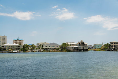 Views of residential villas at the bay in Destin, Florida. There is a sea at the front and view of residences with private docks against the sky background.の写真素材