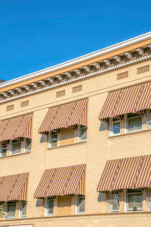 Exterior of residential building in Tucson Arizona with awnings on the windows. A modern apartment or dwelling in a highrise building with blue sky background.の写真素材