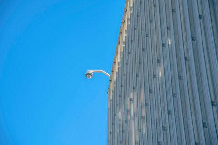 Modern commercial building with cctv security camera in Tucson Arizona. View of a highrise with video surveilance camera installed at the roof for safety.の写真素材