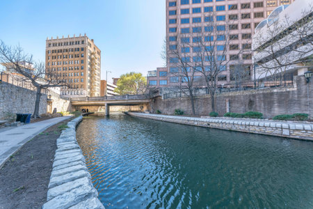 Canal with trails and bridge overlooking buildings at San Antonio River Walk. A river landscape of the famous tourist destination for sightseeing in Texas.の写真素材