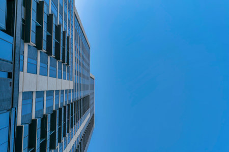 Looking up at clear blue sky and exterior of a modern building on a sunny day. Modern architectural and skyscape views from the city street of Austin Texas.の写真素材