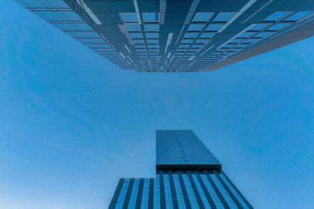 Modern housing in Austin Texas viewed against blue sky with apartments exterior. Looking up at the city skyscape with towering residential buildings featuring glass windows facade.の写真素材