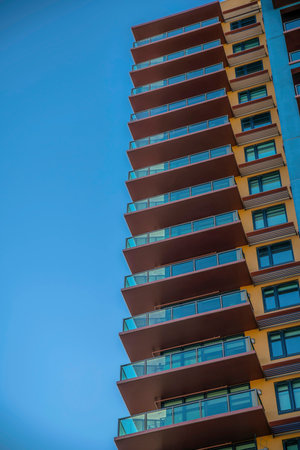 Multi-storey residential building with glass balcony railings- Phoenix, Arizona. Low angle view of a tall building with balconies beside the windows with awnings.の写真素材