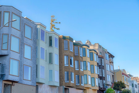 Small apartment buildings with different wall sidings and window structures in San Francisco, CA. Row of apartment buildings with traditional designs against the clear sky background.の写真素材