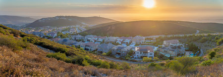 Mountainside residential area in San Diego, California against the sunset in the sky. High view of large houses below and on top of the mountain on the left.の写真素材