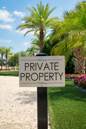Destin, Florida- Sign on a post with Private Property outdoors. Signage against the view of white gravel on the left and landscaped grass, plants, and trees on the right.の写真素材