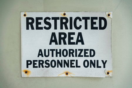 Screwed signage with rust and Restricted Area Authorized Personnel Only- Miami, Florida. Close-up of a sign on a wall with black letterings.の写真素材
