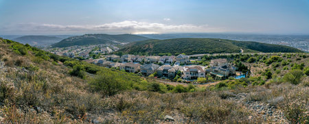 Suburban homes view from a mountain at Double Peak in San Marcos, California. High angle view of a neighborhood in between the hills against the sky.の写真素材