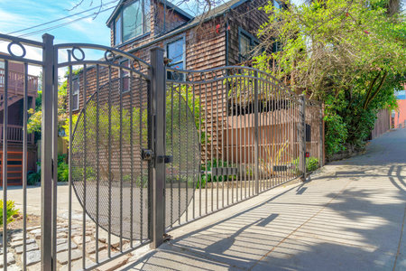 Wrought iron black gate of a residence in San Francisco, California. Front of a house with concrete...