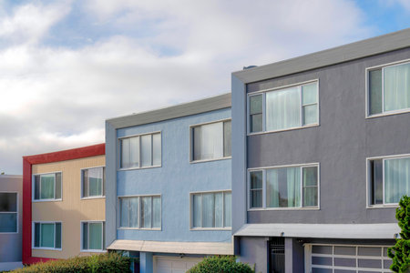 Modern house buildings with reflective picture windows in San Francisco, California. Complex houses with a view of garage doors at the bottom against the sky background.の写真素材
