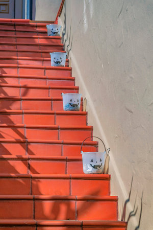 Outdoor terracotta tiles staircase with buckets on the side near the beige wall- San Francisco, CA. Tiled outdoor stairs with ornamental buckets with treats.の写真素材