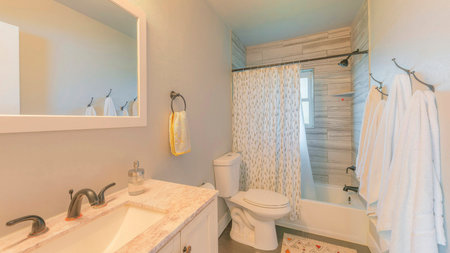 Panorama Bathroom interior with window and warm ambient lighting. There is a vanity sink with marble...