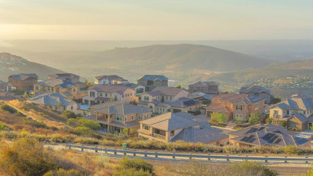 Panorama Puffy clouds at sunset Panoramic high view of San Marcos community at San Diego, California. There is a highway with metal fence near the residential area with large houses and a view of mountains at the back.の写真素材