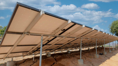 Panorama White puffy clouds Support structures of a solar panels with concrete foundation and tube...
