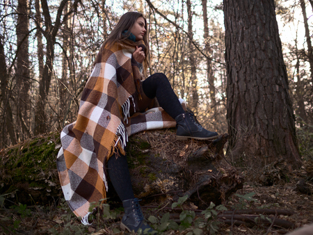 Brunette posing in the forest on a fallen tree. Autumn Walk. autumn mood.の写真素材