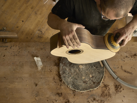 luthier polishes the body of a classical guitar.の写真素材