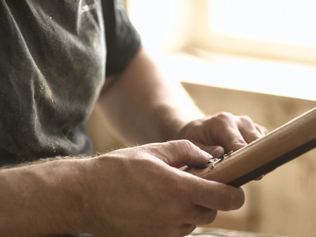 luthier polishes the body of a classical guitar.の写真素材
