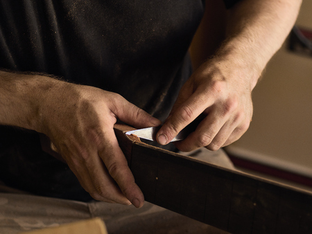 The guitar master makes a guitar neck.