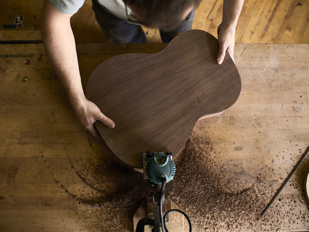 Luthier Install Binding on an guitar. Chamfering on the body of the guitar.の写真素材
