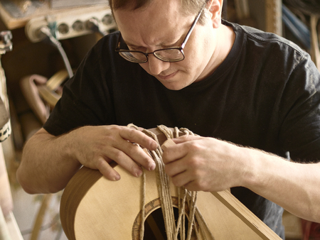 The process of making a cutaway on a classical guitar.