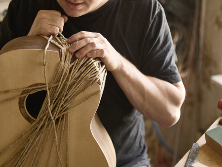 The process of making a cutaway on a classical guitar.