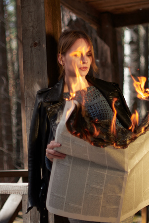 A young woman stands on the porch and reads hot news. A young woman stands on the porch and reads a...