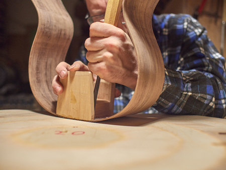 The process of making a classical guitar. Remove excess glue after gluing the tailblock.
