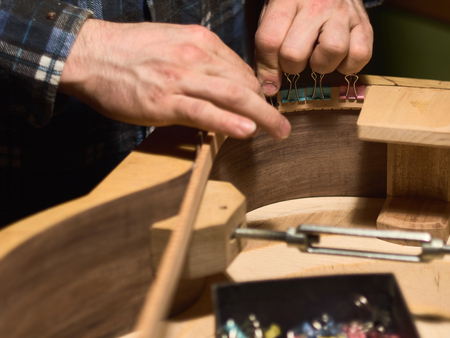 Glue lining to the side of the guitar. The process of making a classical guitar.