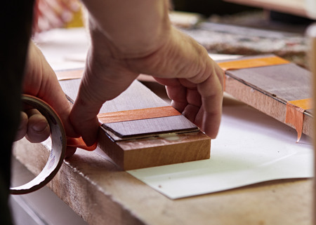 Production of classical guitar. Bonding the head plate to the head of the neck.