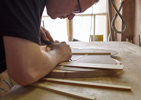 Marking and Pasting brace to the soundboard of a classical guitar. Production of classical guitar.の写真素材