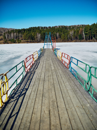 Cold Siberian landscape of a lake strained in the ice. frozen lake and the path to the diving tower.の写真素材