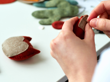 Step-by-step process of manual manufacturing baby crib mobile. Sewing a seam on a toy.の写真素材