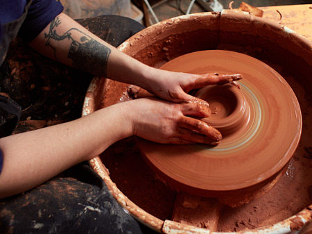 production process of pottery. Forming a clay teapot on a potter's wheel.の写真素材