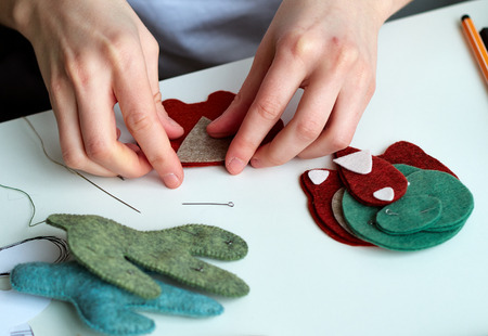 Step-by-step process of manual manufacturing baby crib mobile. Sewing a seam on a toy.の写真素材