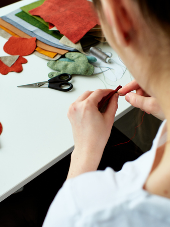 Step-by-step process of manual manufacturing baby crib mobile. Sewing a seam on a toy.