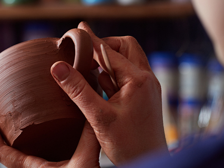 production process of pottery. The potter joins the cup and the handle from the cup.の写真素材