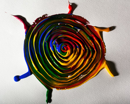 Many multicolored paints mixed and spread on paper and form the pattern of the African sun.の写真素材